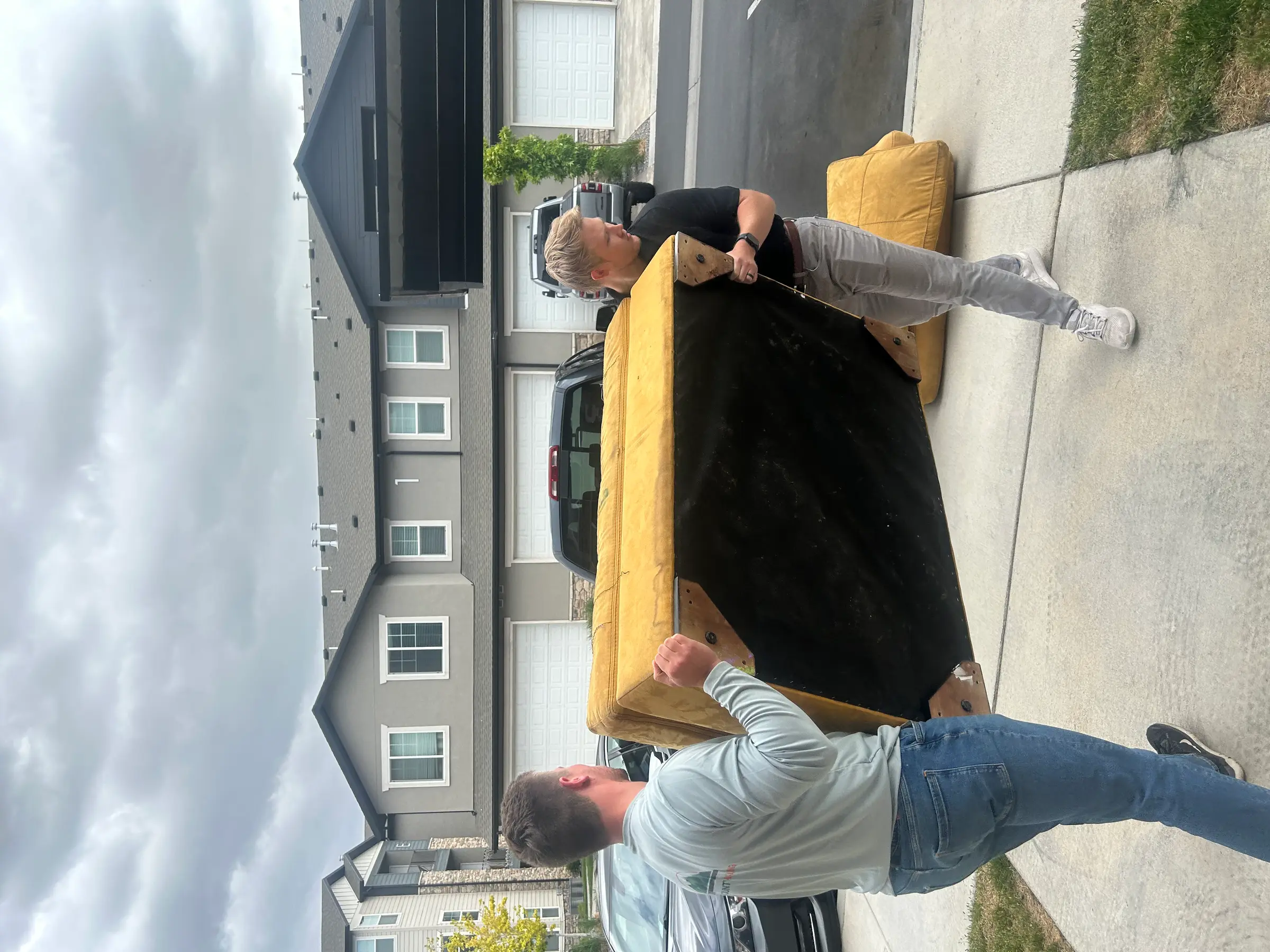 Team lifting a sofa during furniture removal pickup in Utah County