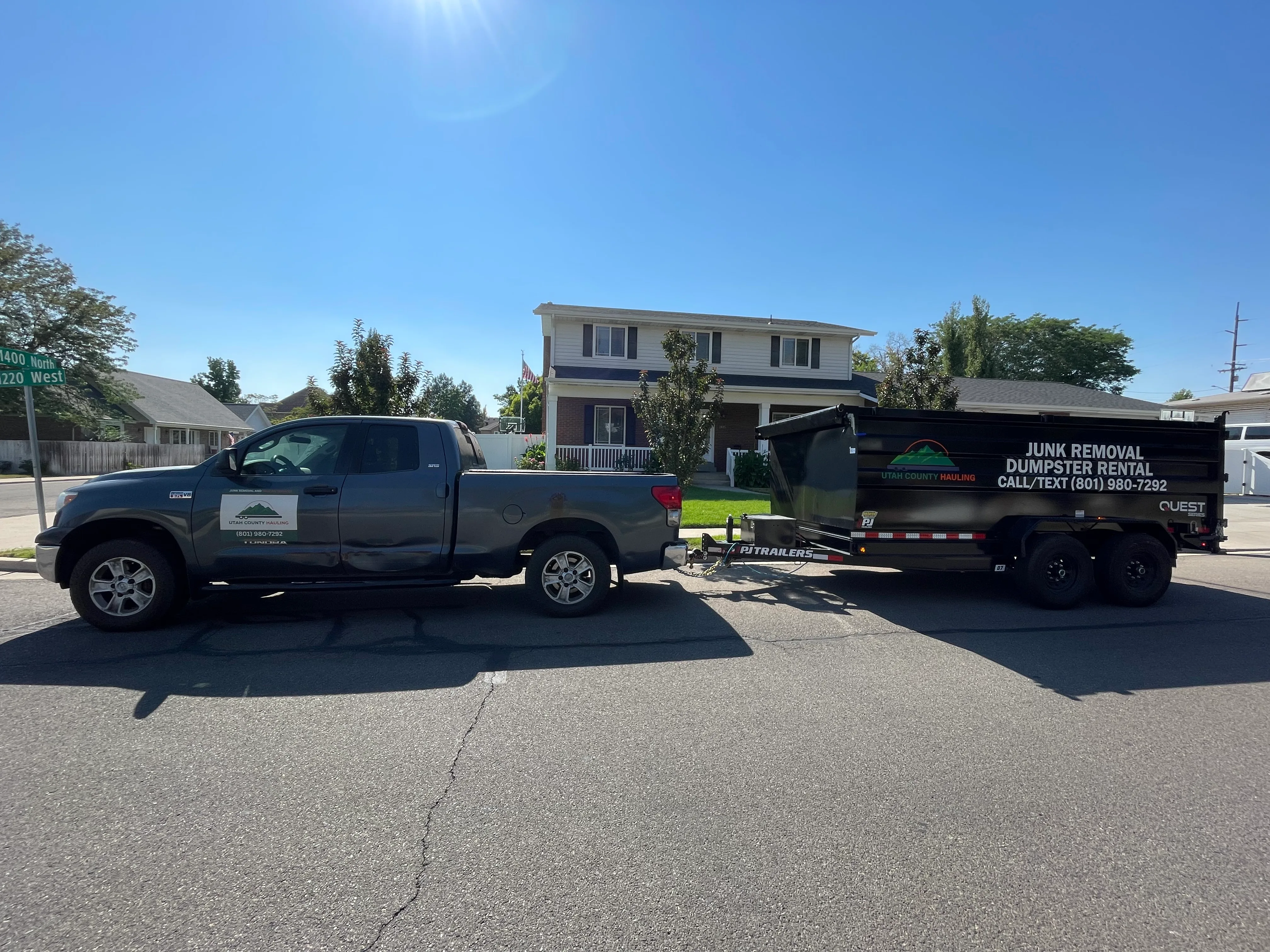 Residential junk hauling truck and trailer parked in a Utah County neighborhood