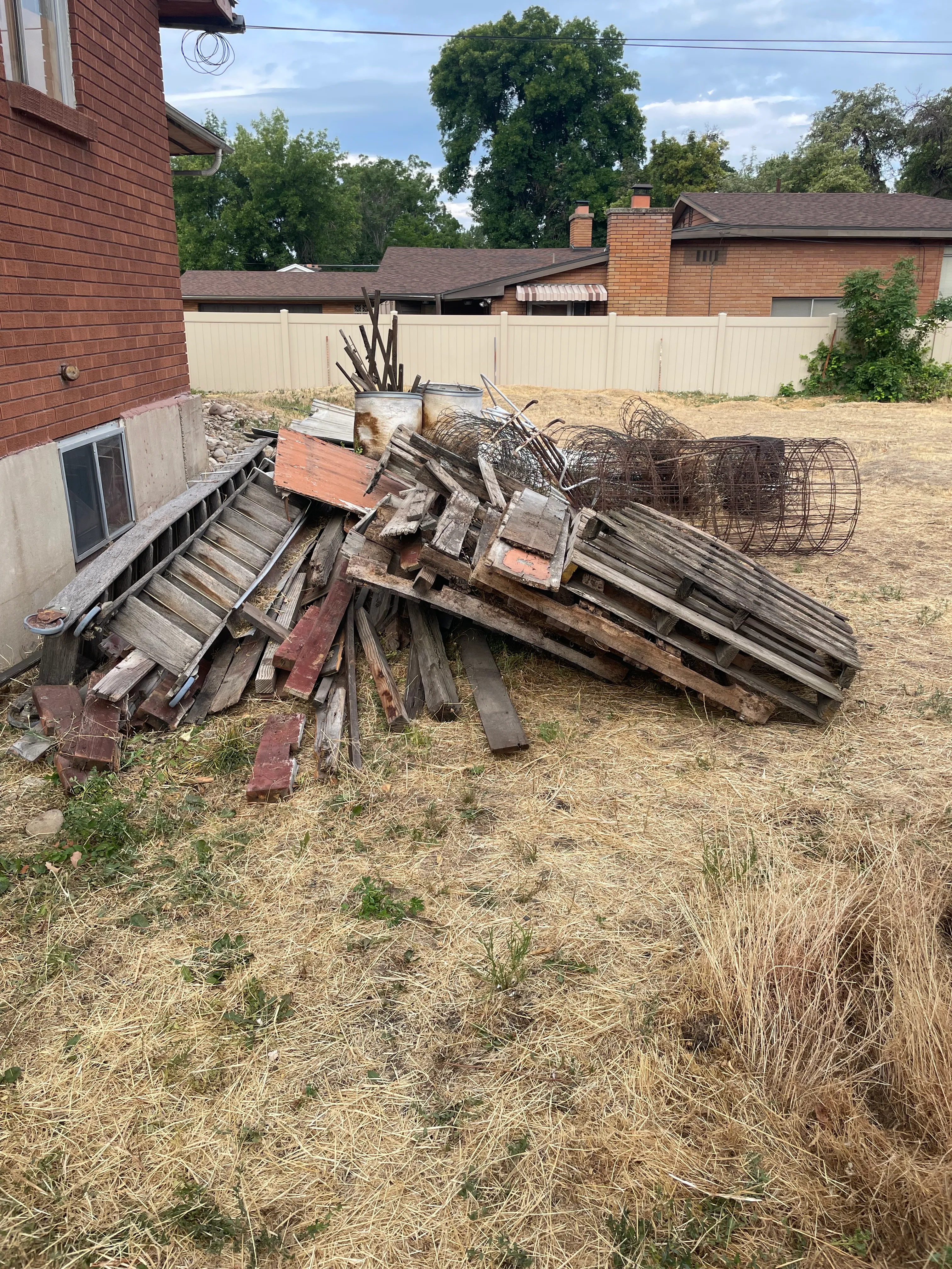 Before yard cleanup with debris pile at a Utah County home